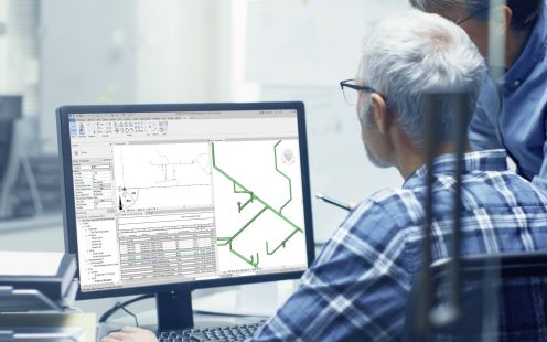 Two Senior Architectural Engineers Working With Building Blueprint on a Personal Computer. They Actively Discuss Various Plans and Schemes.