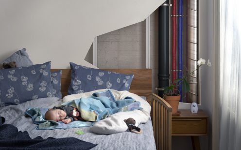A visualization showing a partially open bedroom wall with several piping systems running through it and a baby sleeping soundly nearby | Pipelife 